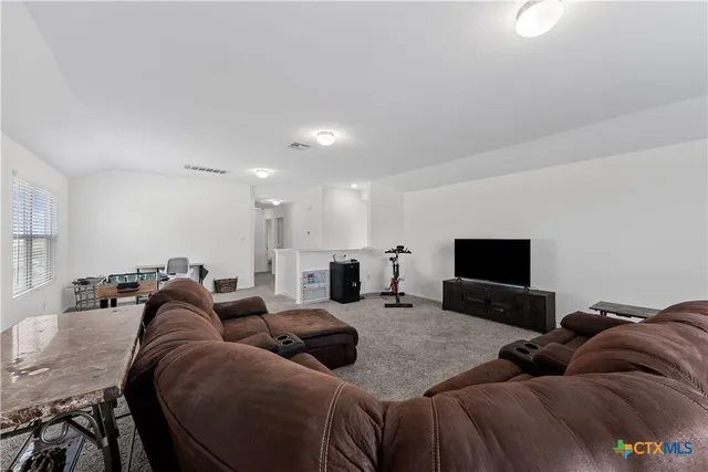 a living room with furniture a couch and a flat screen tv