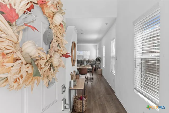 a view of a hallway with wooden floor and a dining room