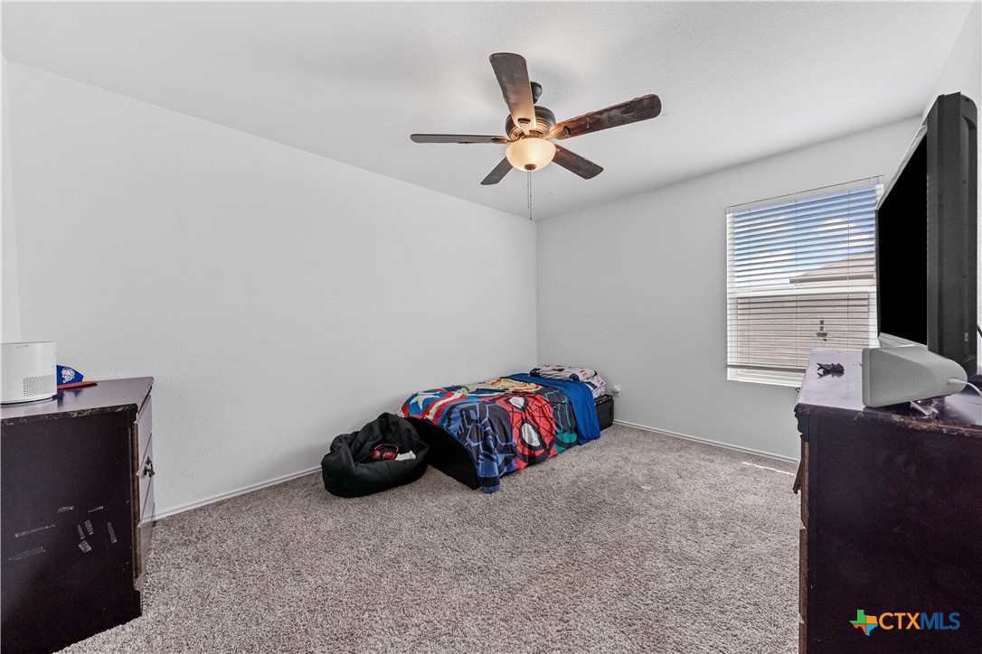 129 Rowdy Yates Way Jarrell, TX 76537 - Photo 31 of 41 a bedroom with a bed and a chandelier