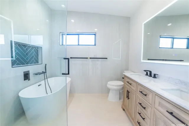 a bathroom with a granite countertop sink toilet and mirror