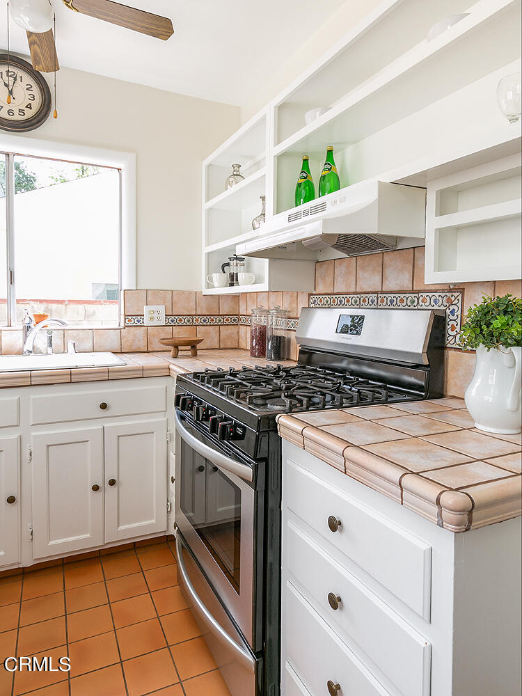 2023 Queensberry Road Pasadena, CA 91104 - Photo 13 of 26 a kitchen with a stove white cabinets and a window