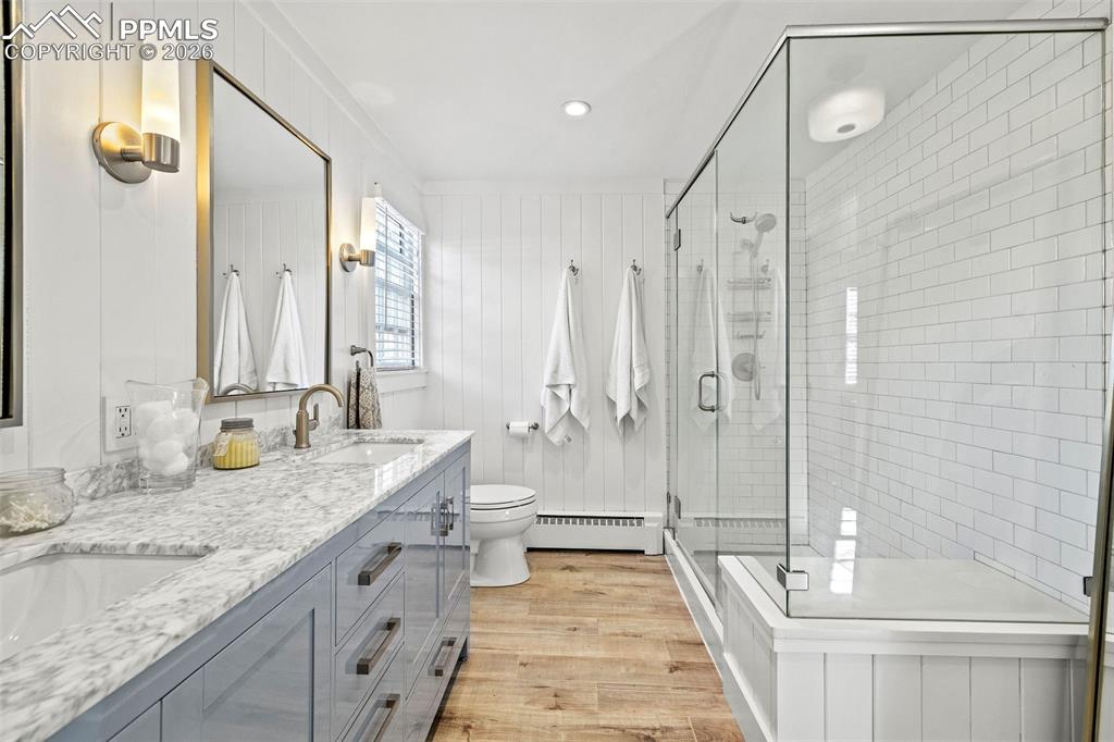 2 Cresta Road Colorado Springs, CO 80906 - Photo 19 of 33 a bathroom with a granite countertop sink a toilet a mirror and shower