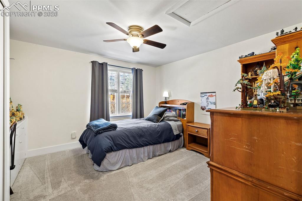 2 Cresta Road Colorado Springs, CO 80906 - Photo 24 of 33 a bedroom with a bed and a chandelier