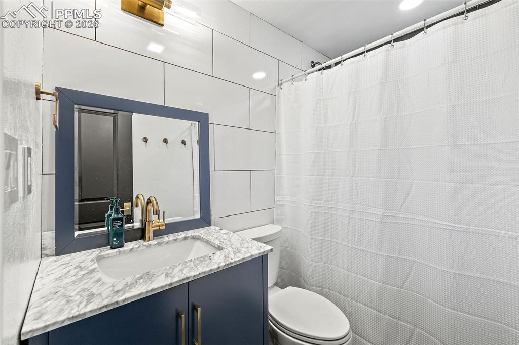 2 Cresta Road Colorado Springs, CO 80906 - Photo 28 of 33 a bathroom with a granite countertop sink toilet and shower