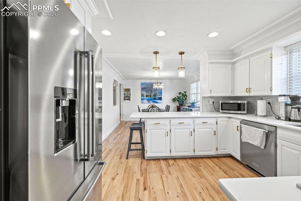 2 Cresta Road Colorado Springs, CO 80906 - Photo 10 of 33 a kitchen with white cabinets appliances and wooden floor