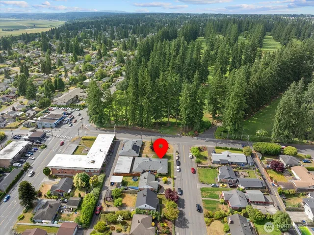 an aerial view of residential houses with outdoor space and trees
