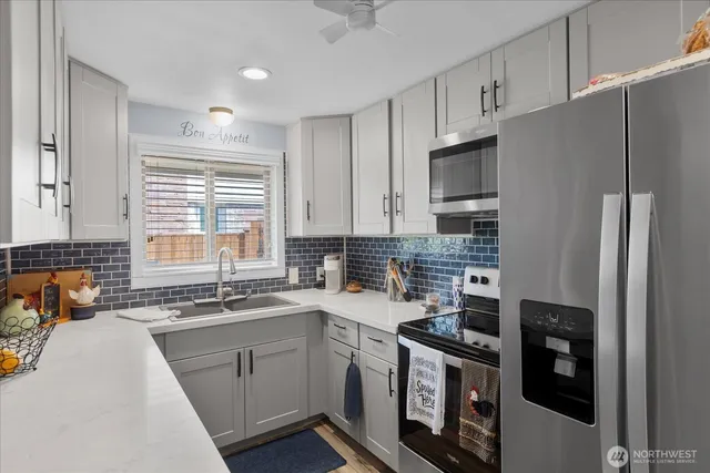 a kitchen with stainless steel appliances a sink stove refrigerator and cabinets