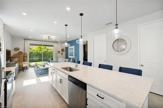 a kitchen with stainless steel appliances granite countertop a stove a refrigerator a kitchen island a table and chairs