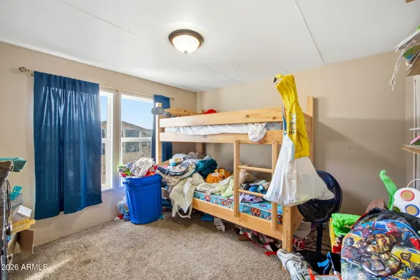 a bedroom with a bed and a wooden floor