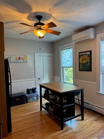 a room with wooden floor pool table and window
