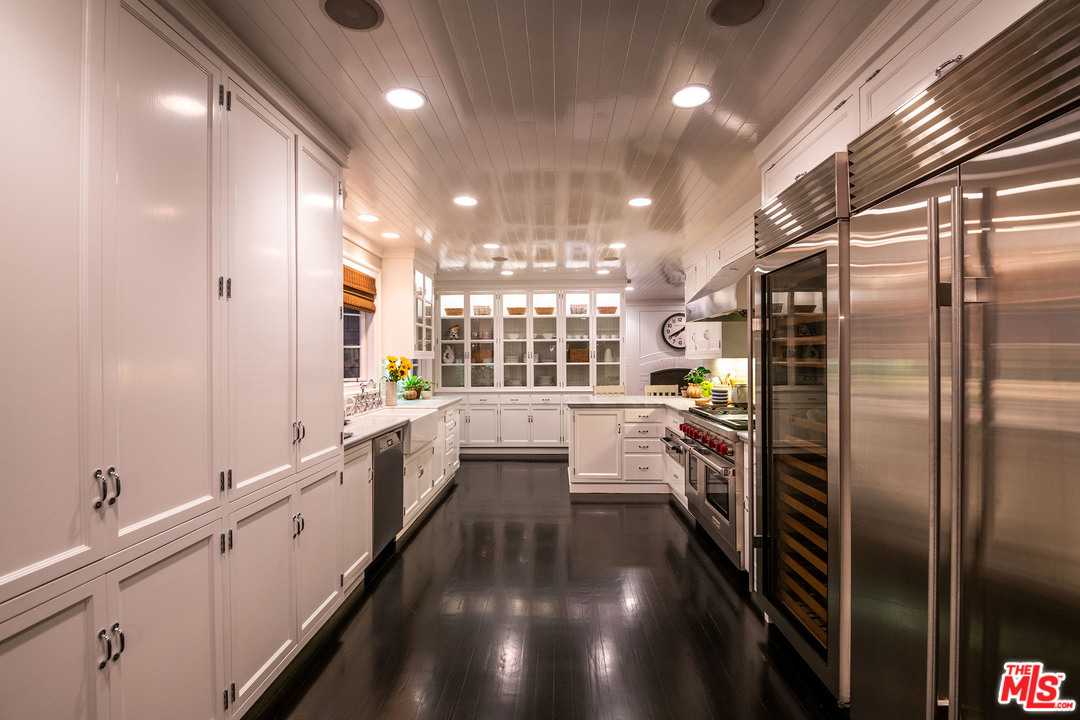 120 Homewood Road Los Angeles, CA 90049 - Photo 13 of 47 a large white kitchen with lots of counter space and stainless steel appliances