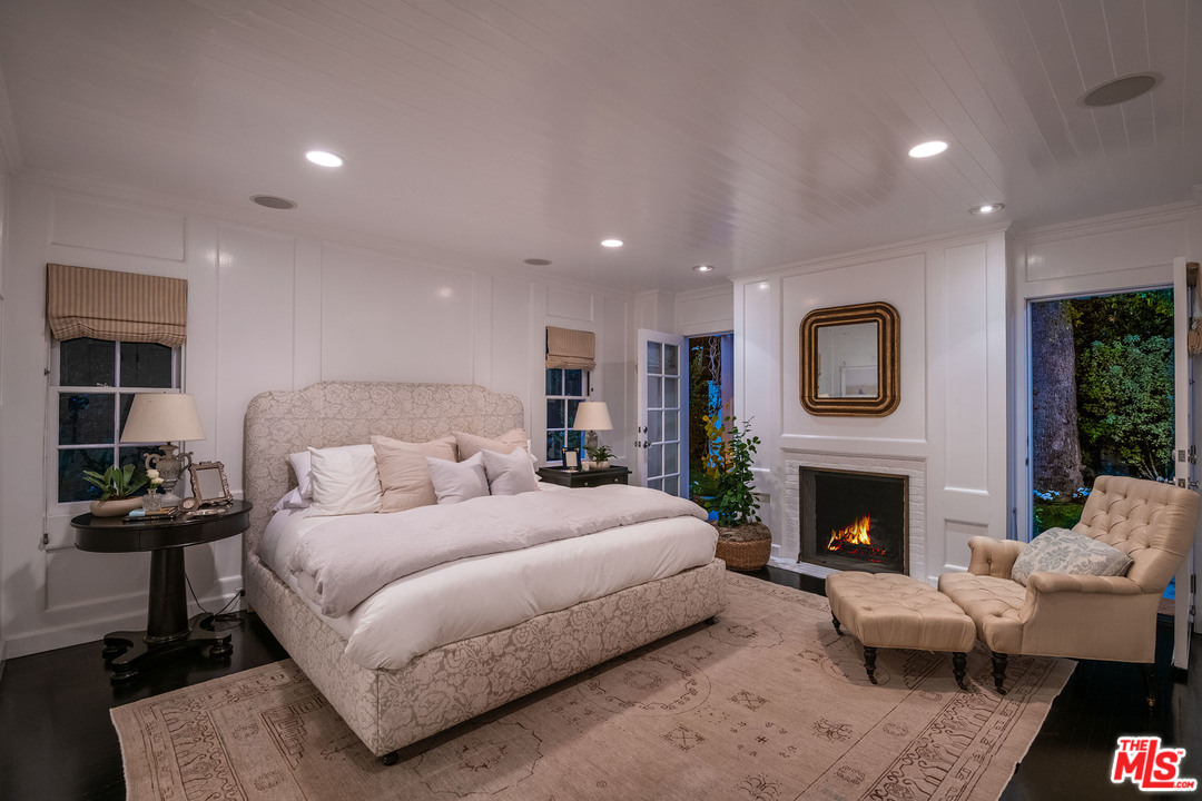 120 Homewood Road Los Angeles, CA 90049 - Photo 16 of 47 a bedroom with a bed and a fireplace