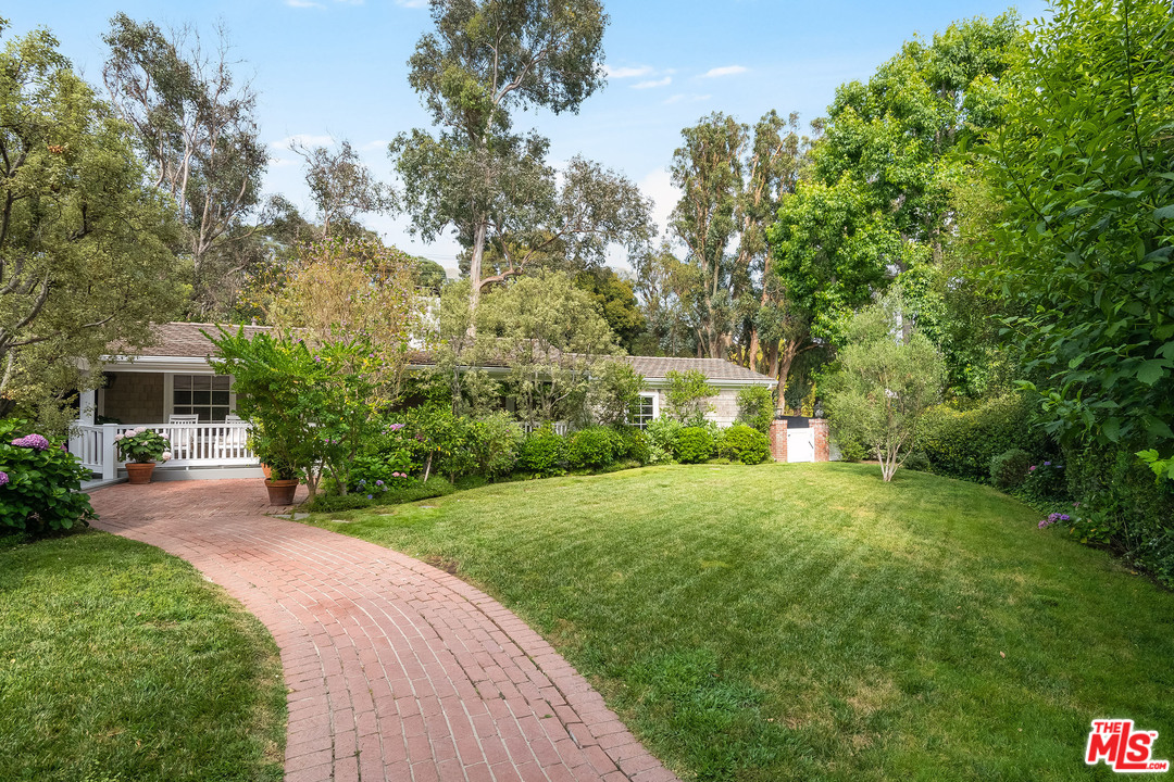 120 Homewood Road Los Angeles, CA 90049 - Photo 19 of 47 a front view of a house with a yard and trees
