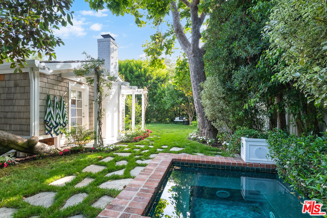 120 Homewood Road Los Angeles, CA 90049 - Photo 31 of 47 a backyard of a house with table and chairs plants and large tree