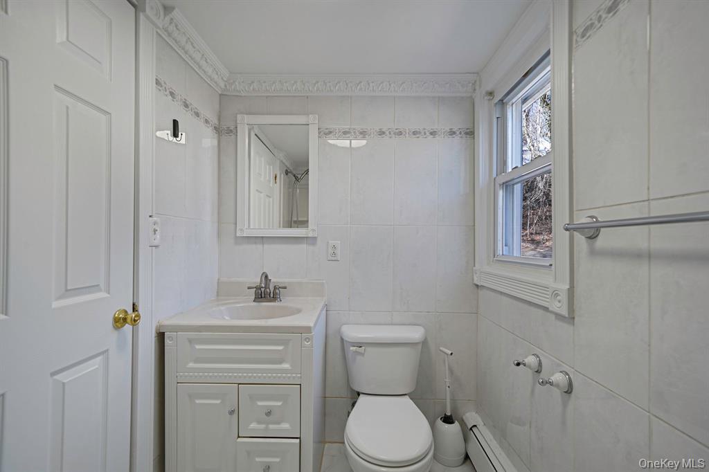 7 Yucca Road, Unit UPPR Rocky Point, NY 11778 - Photo 9 of 18 a bathroom with a toilet sink and mirror