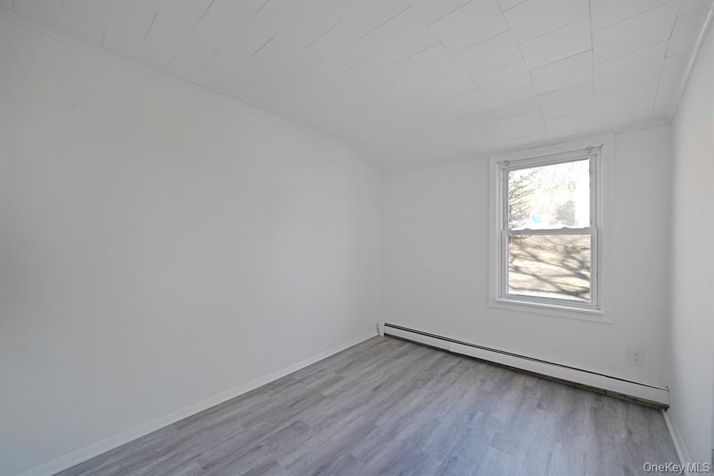7 Yucca Road, Unit UPPR Rocky Point, NY 11778 - Photo 10 of 18 an empty room with wooden floor and windows