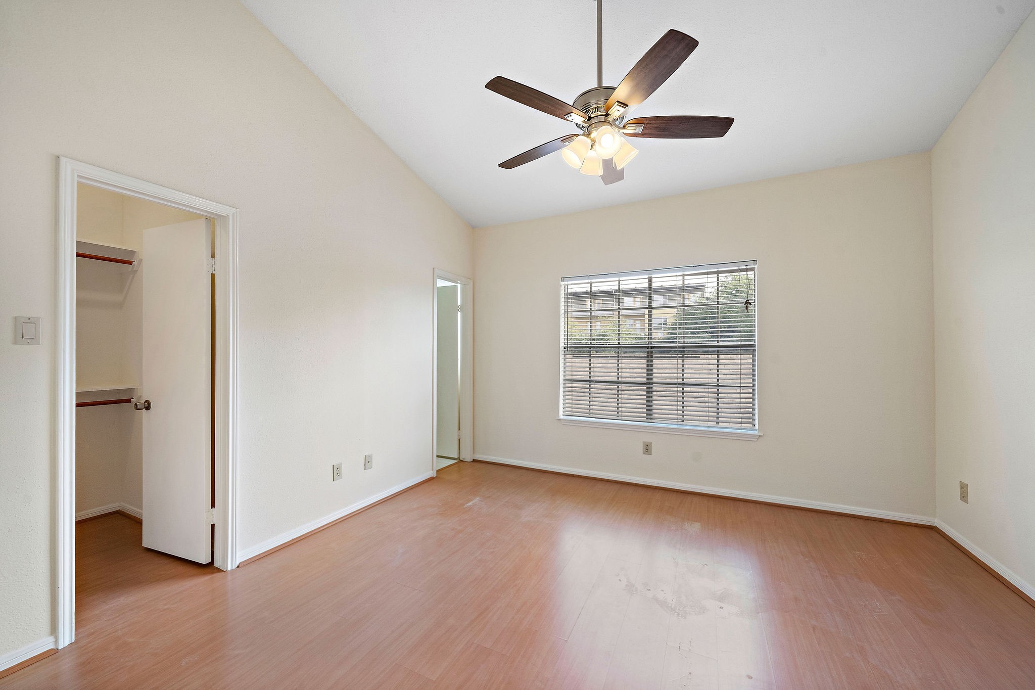 7941 Knight Road, Unit 20 Houston, TX 77054 - Photo 7 of 11 Inviting secondary bedroom with vaulted ceilings, abundant natural light, a walk-in closet, and an ensuite bath for added comfort and privacy.