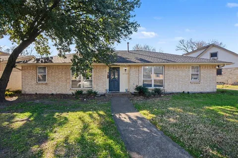 a view of a yard in front of a house with large tree