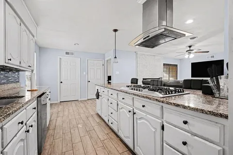 a kitchen with stainless steel appliances white cabinets and a refrigerator