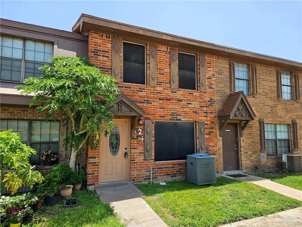 Brick exterior featuring decorative shutters and a gabled entry overhang