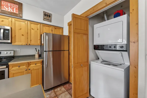 a kitchen with stainless steel appliances granite countertop a refrigerator a stove and a sink with wooden floor