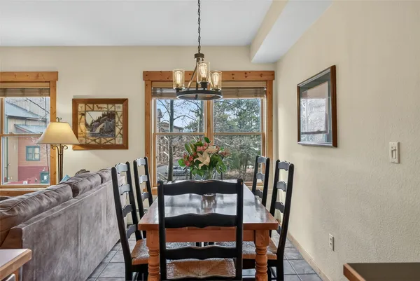 a dining room with furniture a chandelier and window
