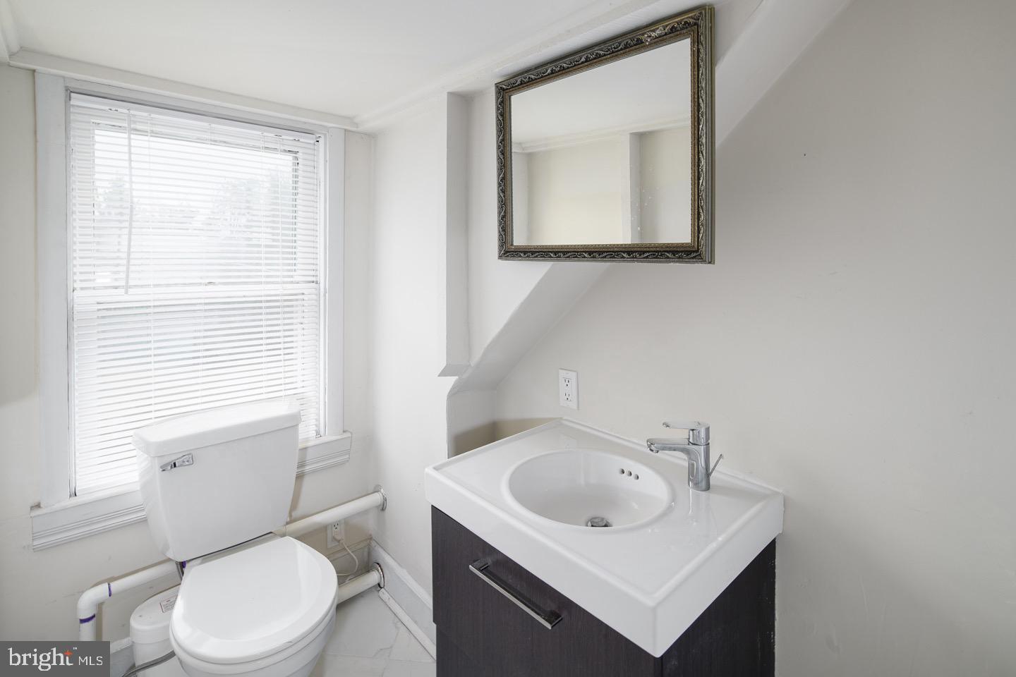 123 Potter Street Haddonfield, NJ 08033 - Photo 28 of 31 a bathroom with a toilet sink vanity and mirror