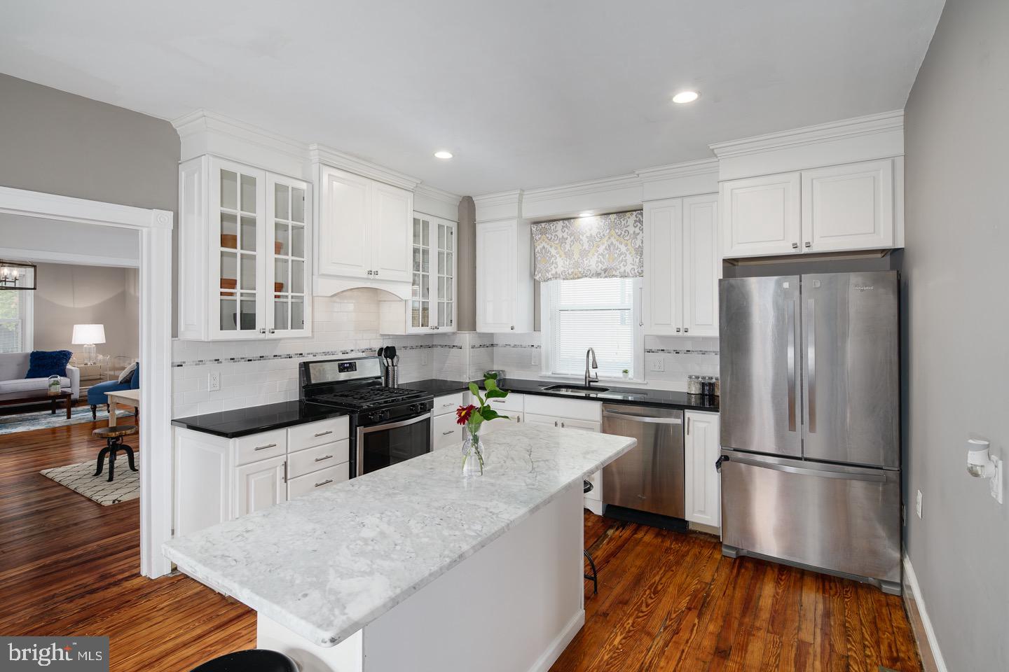 123 Potter Street Haddonfield, NJ 08033 - Photo 8 of 31 a kitchen with a refrigerator a sink dishwasher a stove and white cabinets with wooden floor