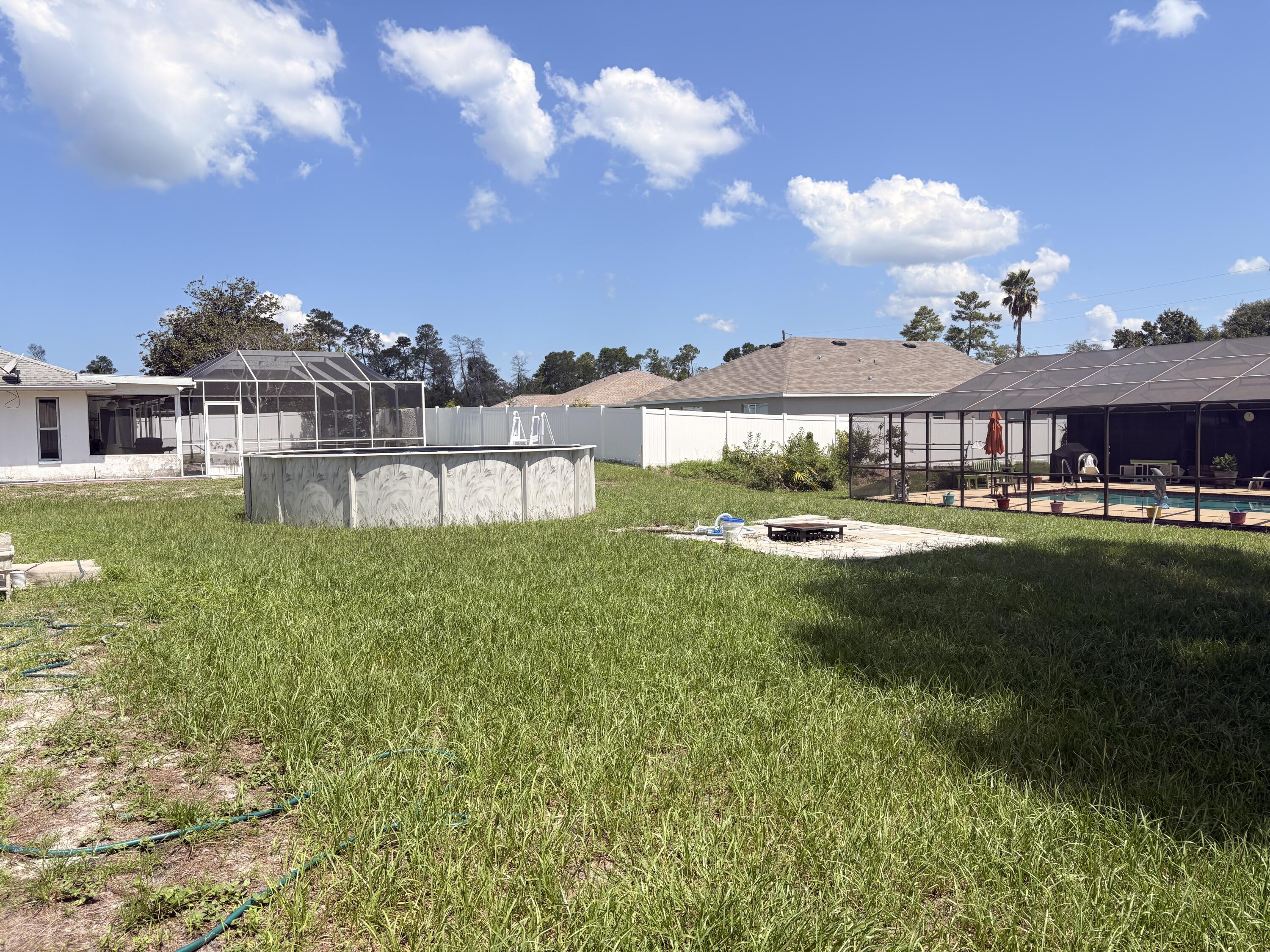 9237 Swiss Road Spring Hill, FL 34606 - Photo 11 of 11 a view of a big house with a big yard and potted plants