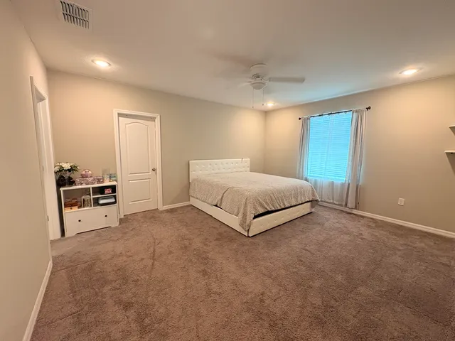 a spacious bedroom with a bed and cabinets