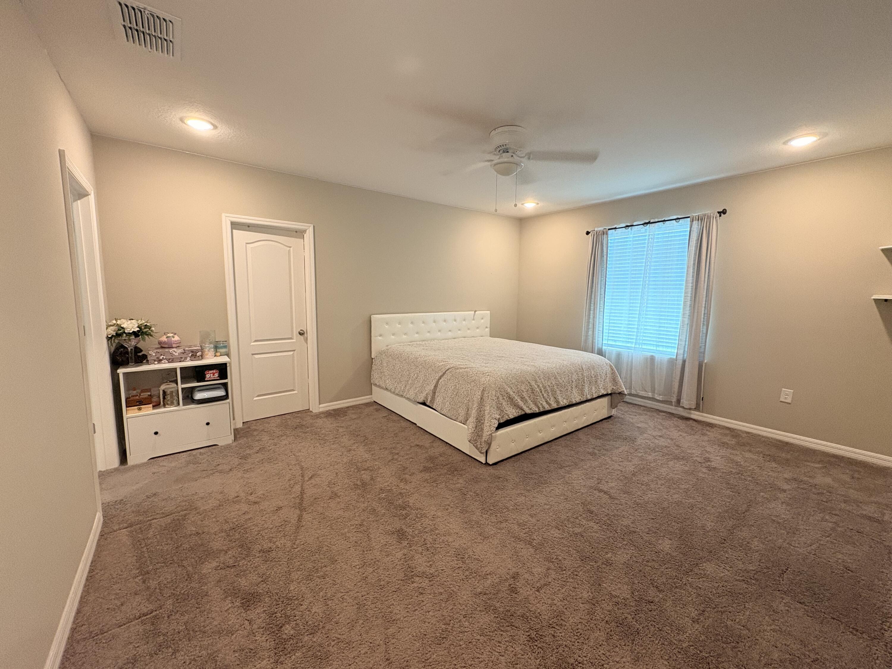 9237 Swiss Road Spring Hill, FL 34606 - Photo 2 of 11 a spacious bedroom with a bed and cabinets