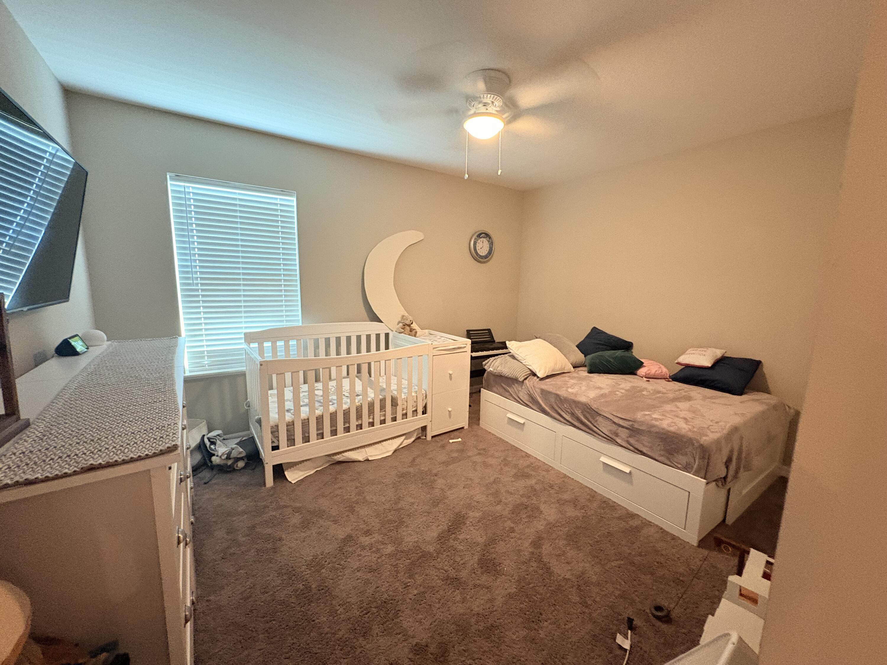 9237 Swiss Road Spring Hill, FL 34606 - Photo 7 of 11 a bedroom with a bed and a chandelier