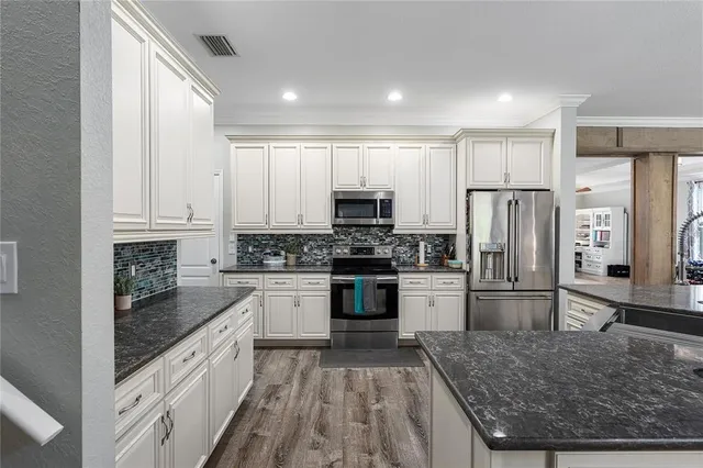 a kitchen with refrigerator cabinets and wooden floor