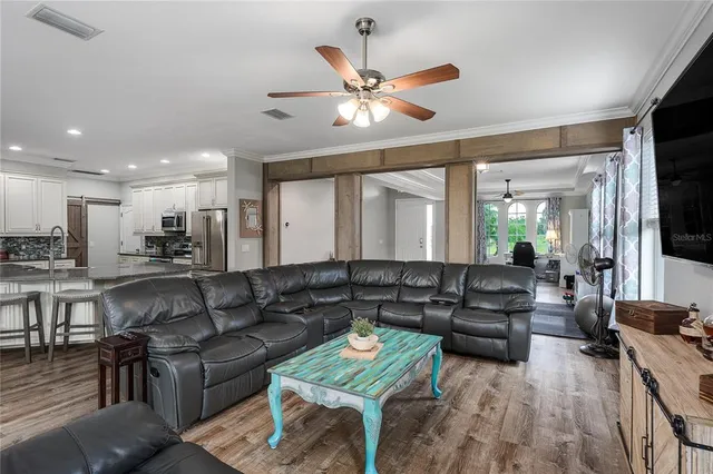 a living room with furniture and a flat screen tv with wooden floor