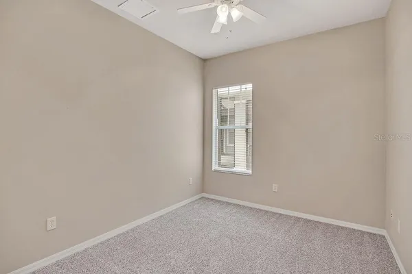 an empty room with a chandelier fan