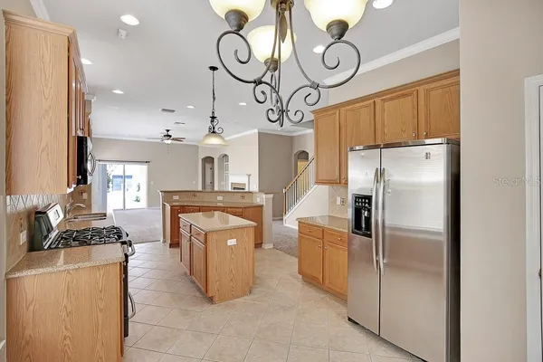 a kitchen with stainless steel appliances granite countertop a refrigerator a oven and white cabinets