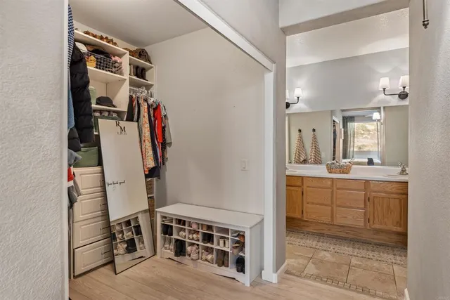 a view of walk in closet with clothes and shoes