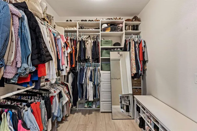 a view of walk in closet with clothes