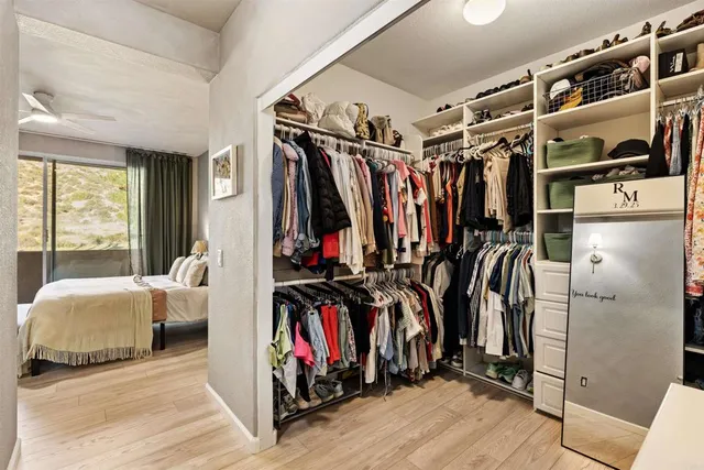 a view of walk in closet with clothes and shoes