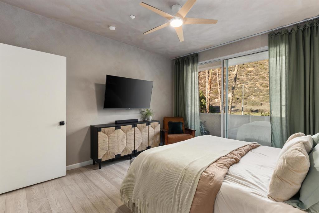 3183 Dehesa Road, Unit 19 El Cajon, CA 92019 - Photo 10 of 26 a bedroom with bed and flat tv with wooden floor