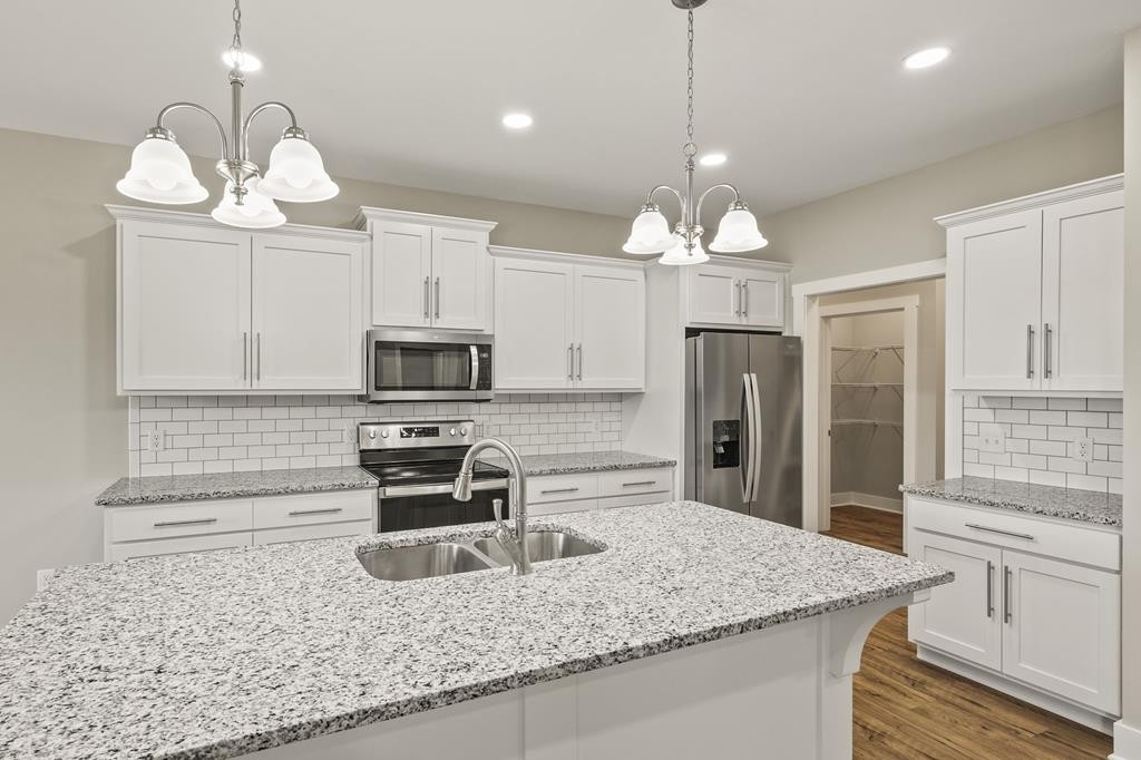 4595 Window Cliff Road Baxter, TN 38544 - Photo 6 of 30 a kitchen with stainless steel appliances granite countertop a sink refrigerator stove and microwave