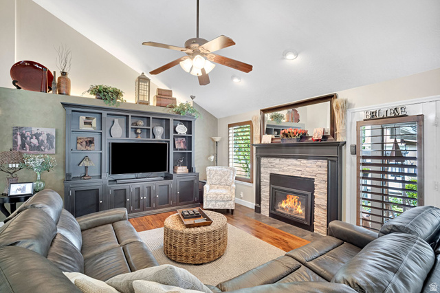 2139 Village Point Way Sandy, UT 84093 - Photo 6 of 35 Vaulted ceiling great room, heatilator fireplace with updated stone and a dark wood mantel, built-in entertainment center, ceiling fan, and plantation shutters. Cove lighting for beautiful accent.