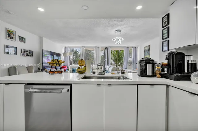 a kitchen with stainless steel appliances granite countertop a sink and a refrigerator
