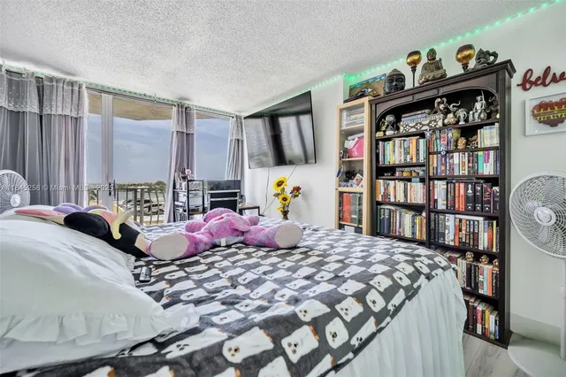 a bedroom with a bed a large window and book shelf