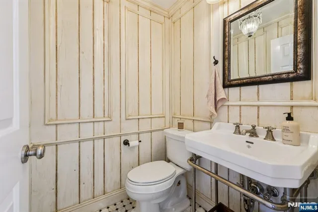 a bathroom with a sink a toilet and a mirror