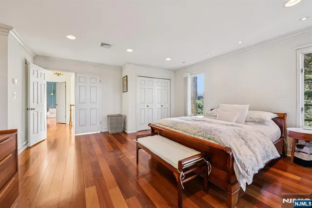 a spacious bedroom with a bed and wooden floor