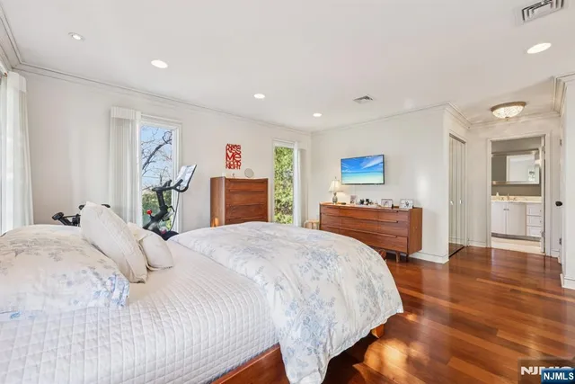 a spacious bedroom with a bed and a flat screen tv