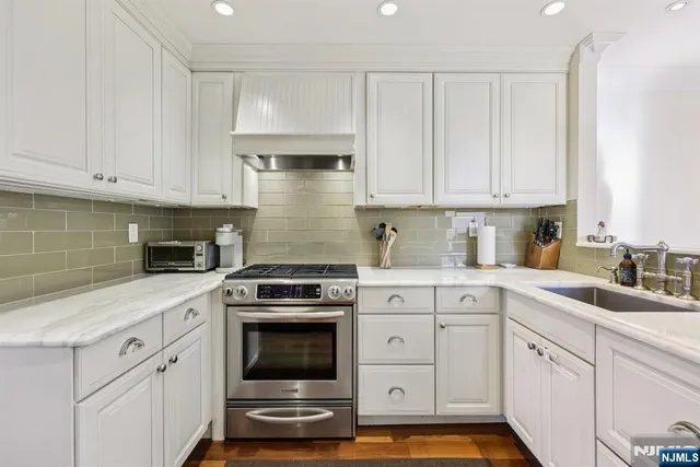 a kitchen with granite countertop white cabinets and white appliances