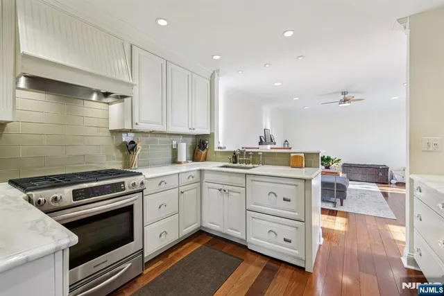 a kitchen with granite countertop cabinets stainless steel appliances and wooden floor