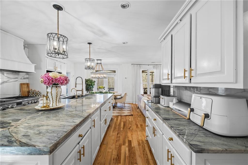 2668 New Hope Road Dacula, GA 30019 - Photo 14 of 65 a kitchen with kitchen island granite countertop a sink dishwasher stove and white cabinets